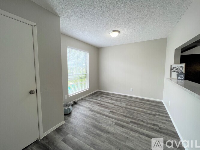 A room with a grey floor and white walls is available for rent.
