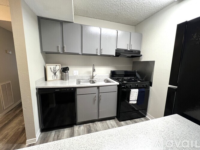 A kitchen with black appliances and white cabinets.