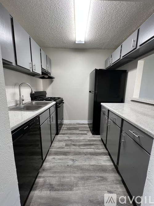 A kitchen with black appliances and cabinets.