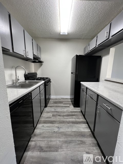A kitchen with black appliances and cabinets.