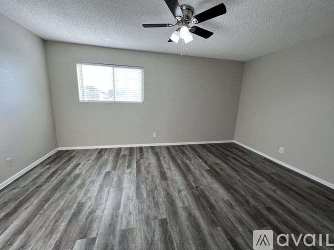 A room with a ceiling fan and a window.