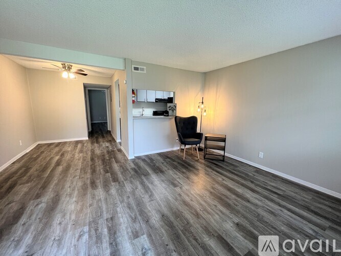 A room with wood flooring and a black chair.