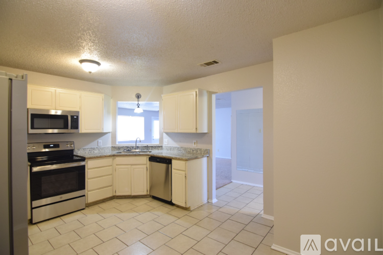 A kitchen with white cabinets and appliances.