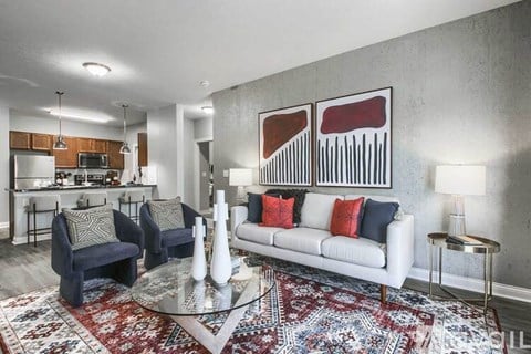 A living room with a white couch and a rug.