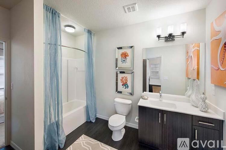 A bathroom with a toilet, sink, and shower curtain.