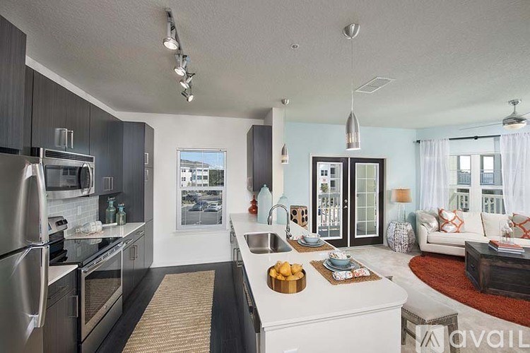 A modern kitchen with a refrigerator, microwave, and oven.
