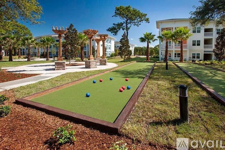 A miniature golf course is located in front of a building with palm trees.
