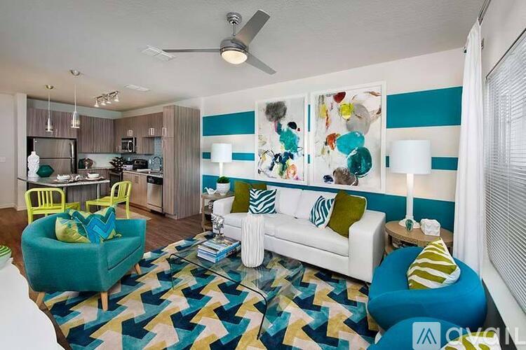 A living room with a white couch and a blue chair.
