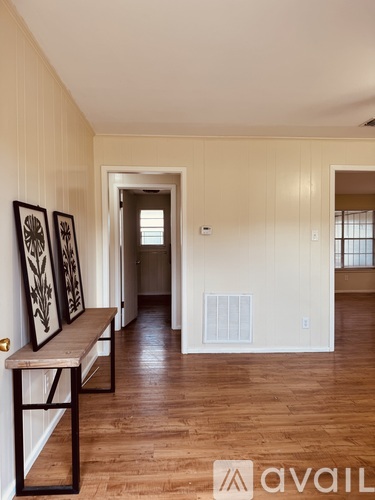 A hallway with a bench and pictures on the wall.