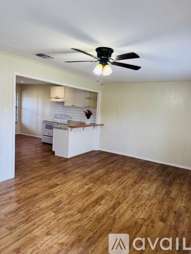 A room with a ceiling fan and wooden flooring.