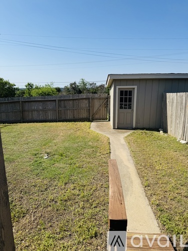 A wooden fence and a small building with a door are visible in the image.