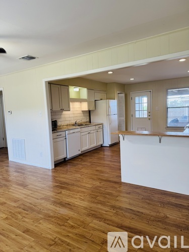 A spacious kitchen with wooden floors and a countertop.