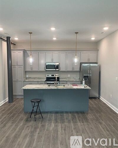 A kitchen with a bar stool in front of it.
