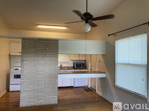 A kitchen with a brick column and a fan.
