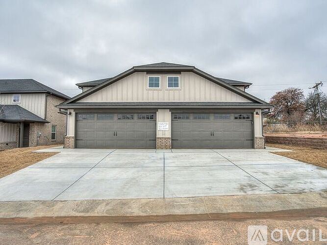 A two-car garage with a house in the background.