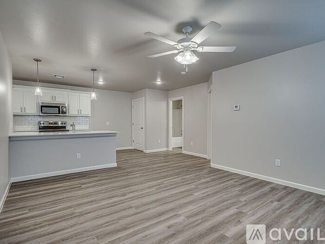 A spacious room with a ceiling fan and lighting fixtures.