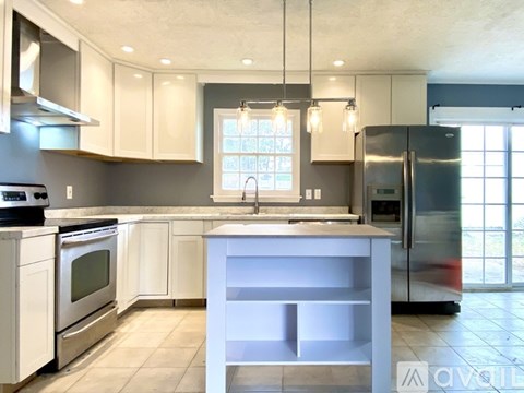 A modern kitchen with white cabinets and stainless steel appliances.