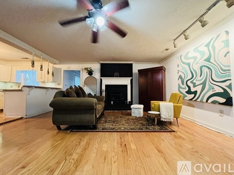 A living room with a green couch, a yellow chair, and a fireplace.