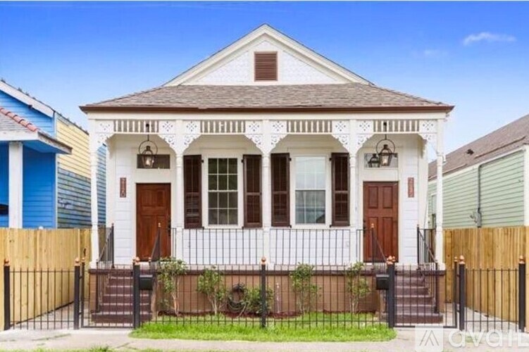 A white house with a brown door and windows.
