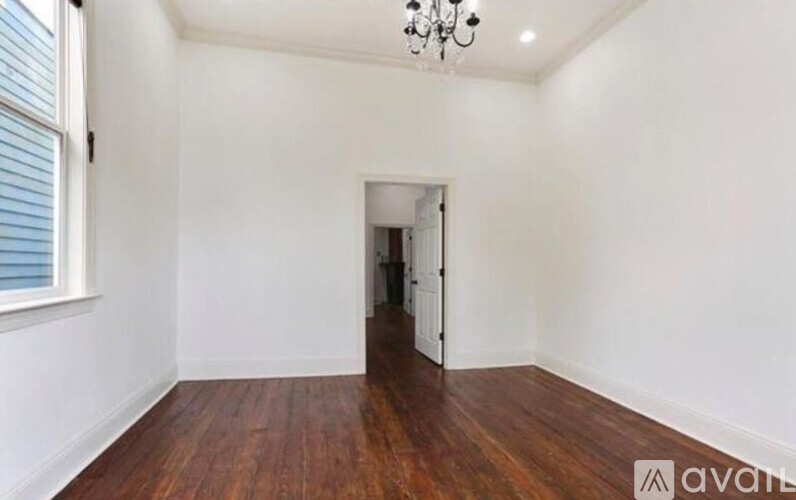 A room with wooden floors and a chandelier.