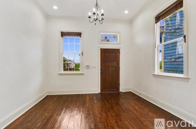 A room with wooden floors and a chandelier.
