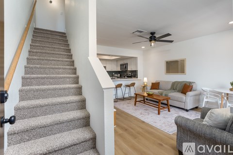 A living room with a grey couch and a wooden floor.