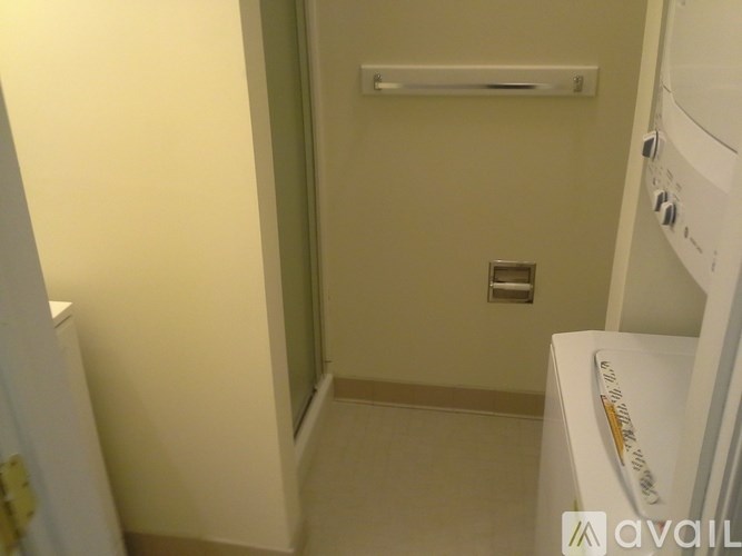 A small, narrow bathroom with a toilet and a washing machine.