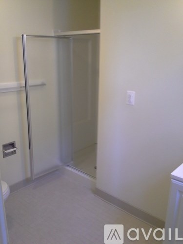 A bathroom with a glass shower door and a toilet.