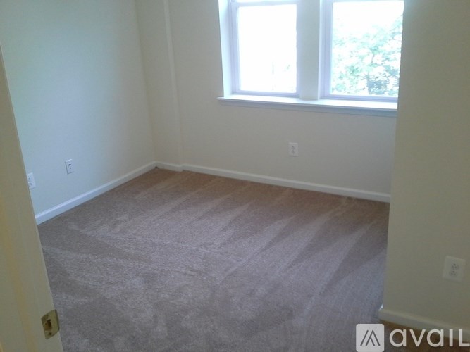 A room with a carpeted floor and a window.