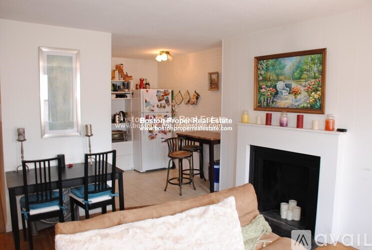 A living room with a fireplace and a painting on the wall.