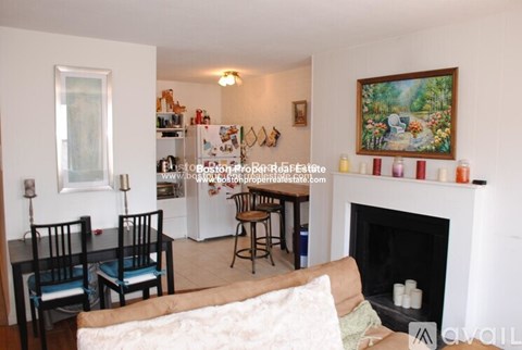 A living room with a fireplace and a painting on the wall.