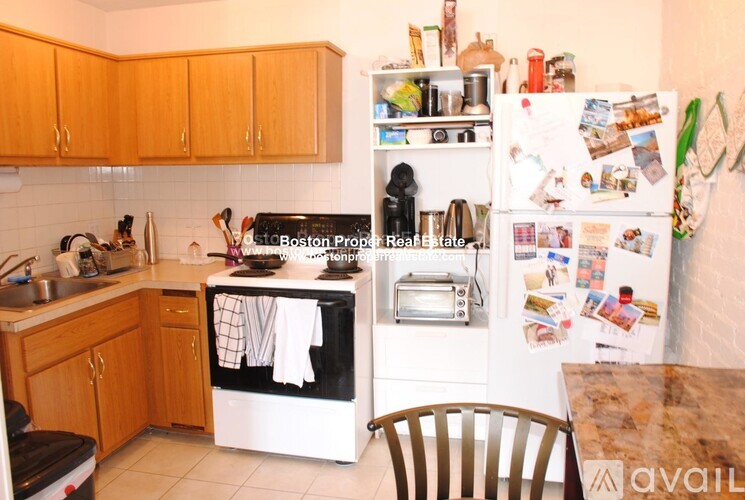 A kitchen with wooden cabinets and a refrigerator covered in magnets and papers.