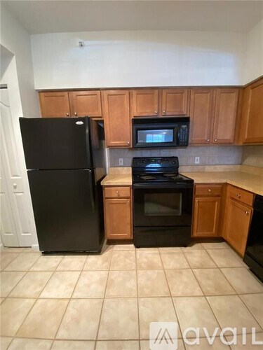 A kitchen with black appliances and wooden cabinets.