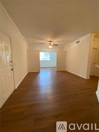 A long hallway with wooden floors and white walls.