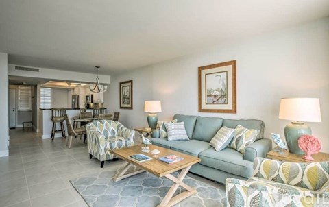 A living room with a grey couch and a wooden coffee table.