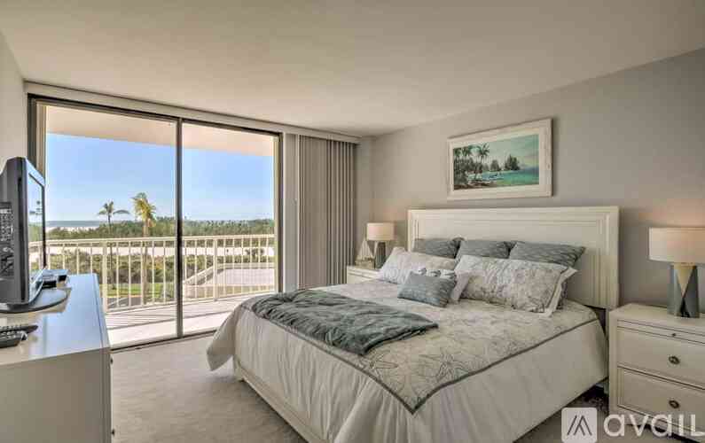 A bedroom with a large bed and a view of the ocean through the window.