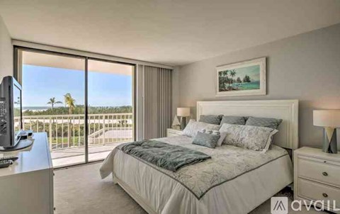 A bedroom with a large bed and a view of the ocean through the window.