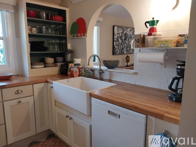A kitchen with a white dishwasher and wooden countertop.