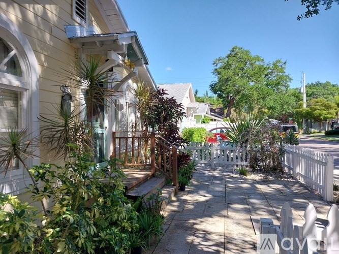 A sunny day in a quiet residential street with a yellow house on the left.