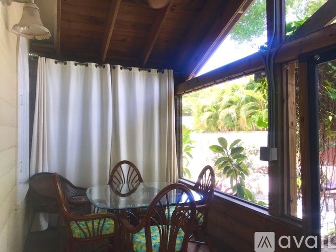 A table and chairs are set up on a balcony with a view of the outdoors.