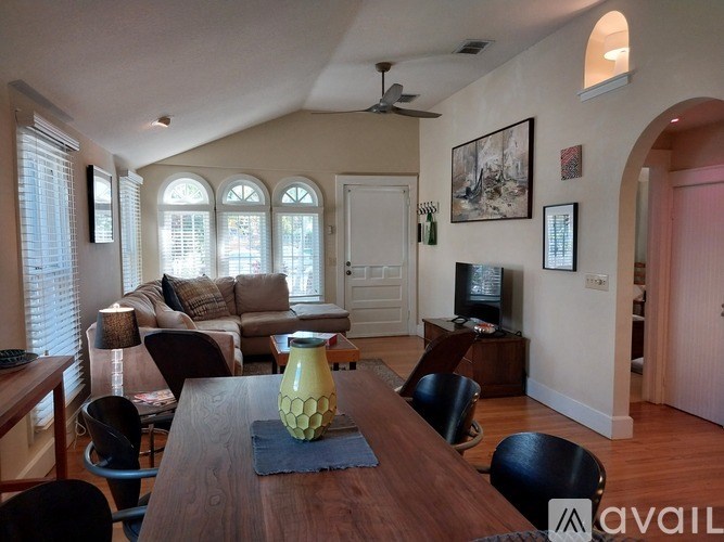 A living room with a couch, chairs, and a television.