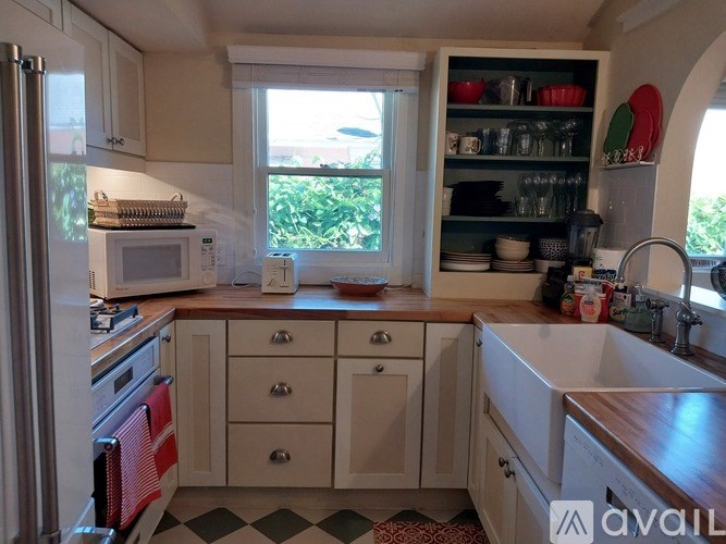 A kitchen with a checkered floor and a window.