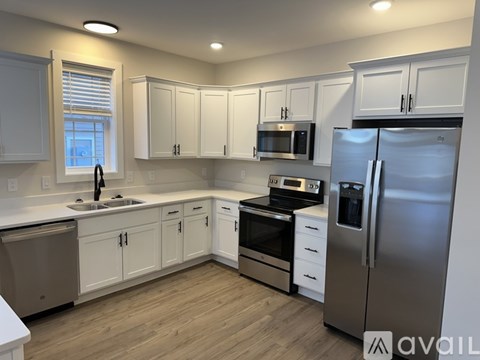 A kitchen with white cabinets and stainless steel appliances.