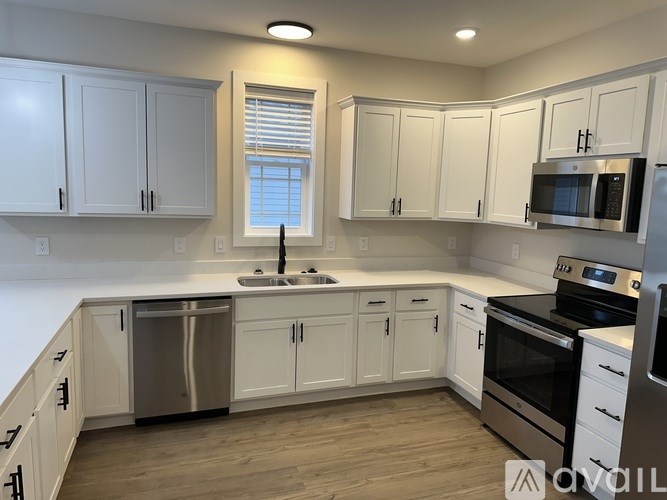 A kitchen with white cabinets and stainless steel appliances.