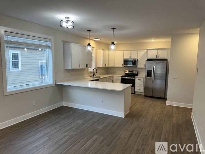 A kitchen with a refrigerator, sink, and cabinets.