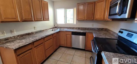 A kitchen with wooden cabinets and granite countertops.
