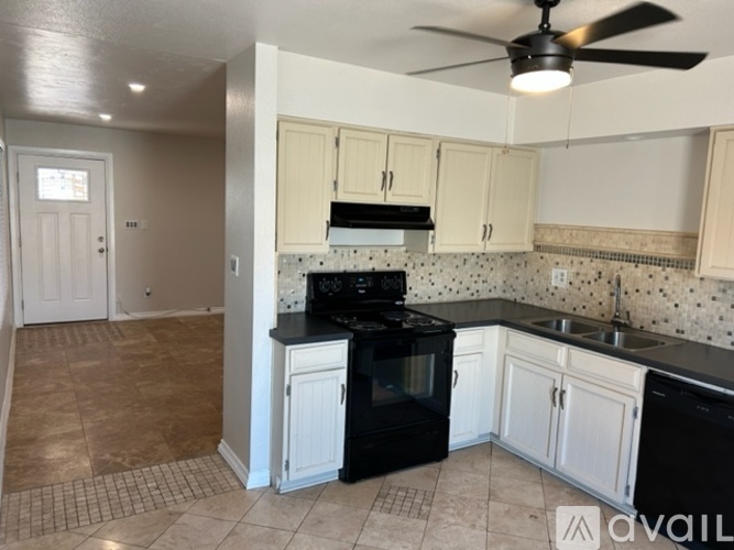A kitchen with black appliances and white cabinets.