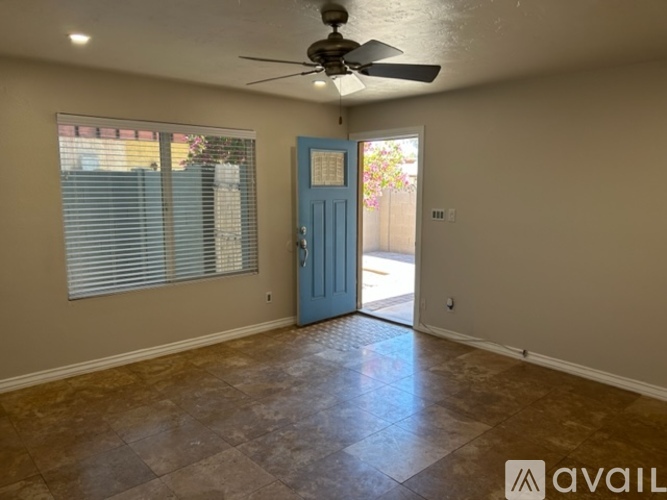 A room with a blue door and a ceiling fan.