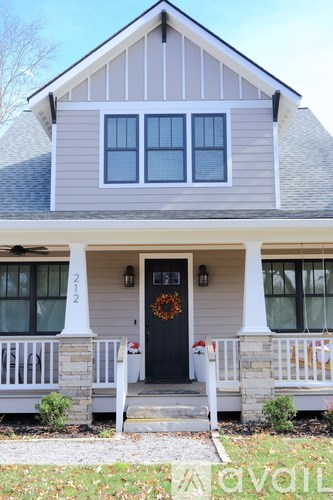 A house with a black front door and a wreath on it.