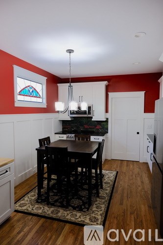 A kitchen with a table and chairs in the middle.